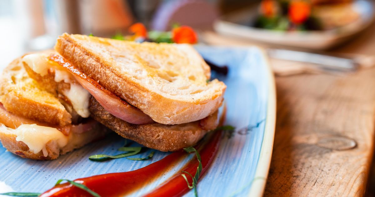 A toasted bacon, cheese and chocolate sandwich on a plate