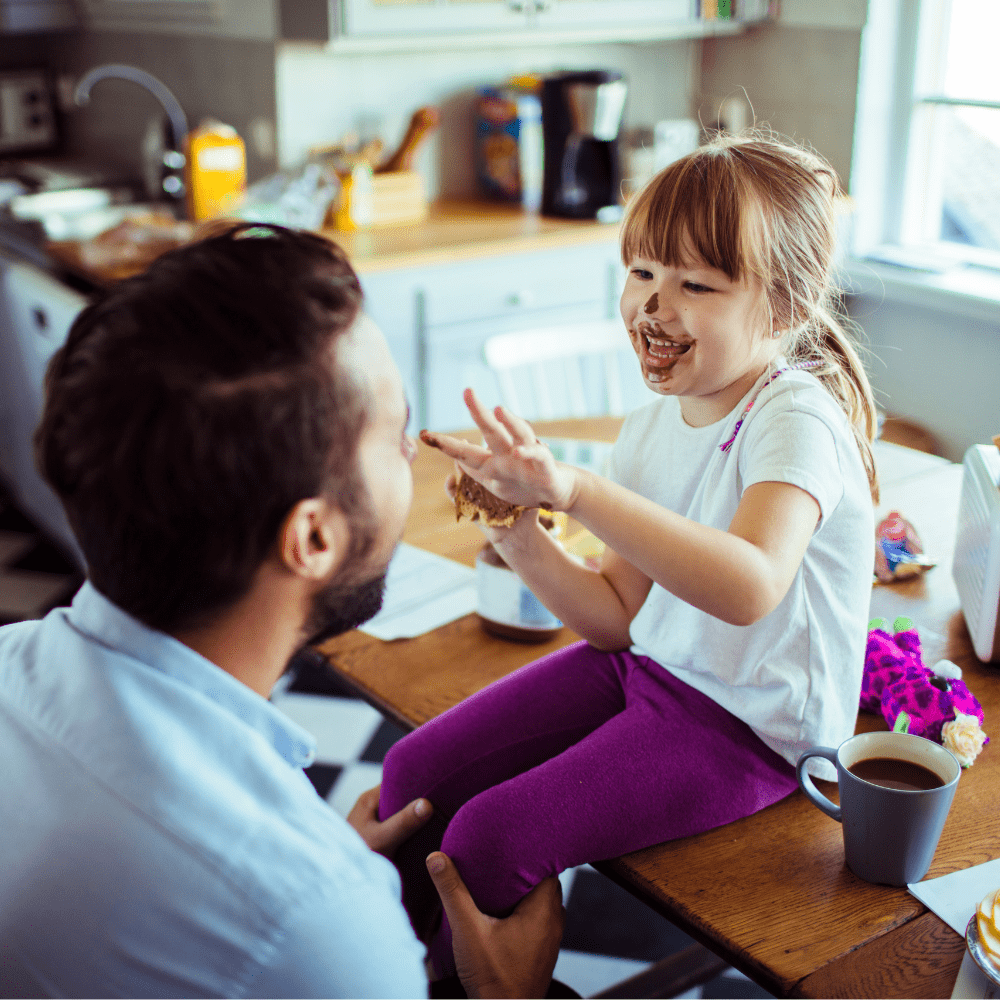A man playing with melted chocolate with his child